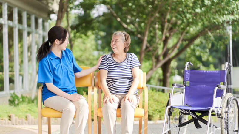 高齢者と笑顔で会話する介護士